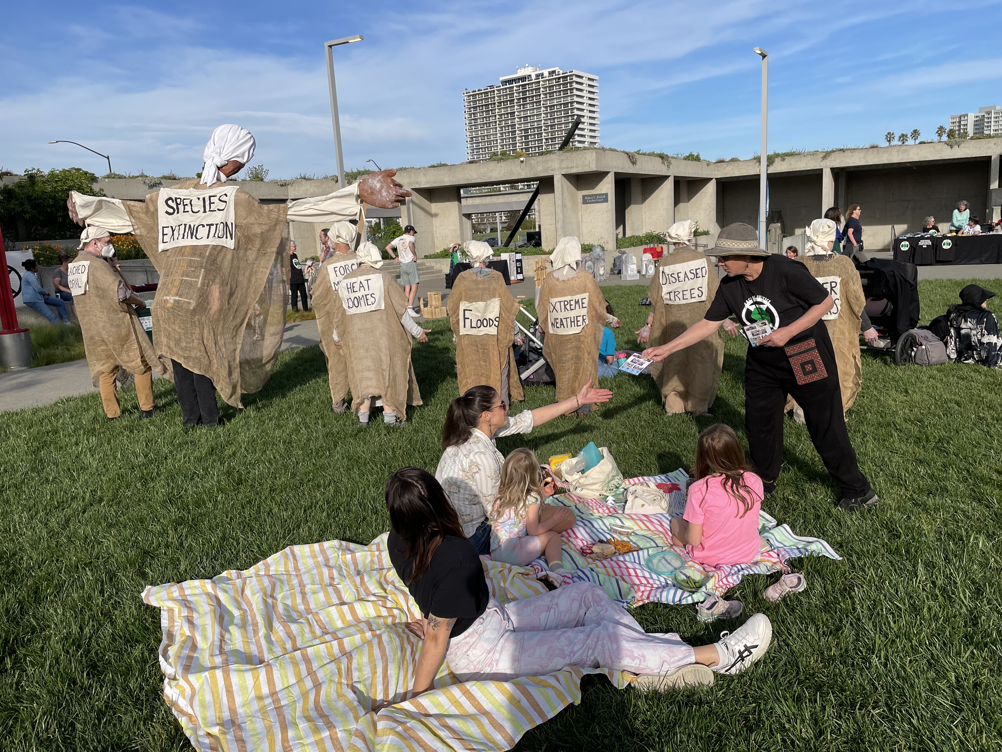 Engager hands our flyers to group picnicking on a blanket