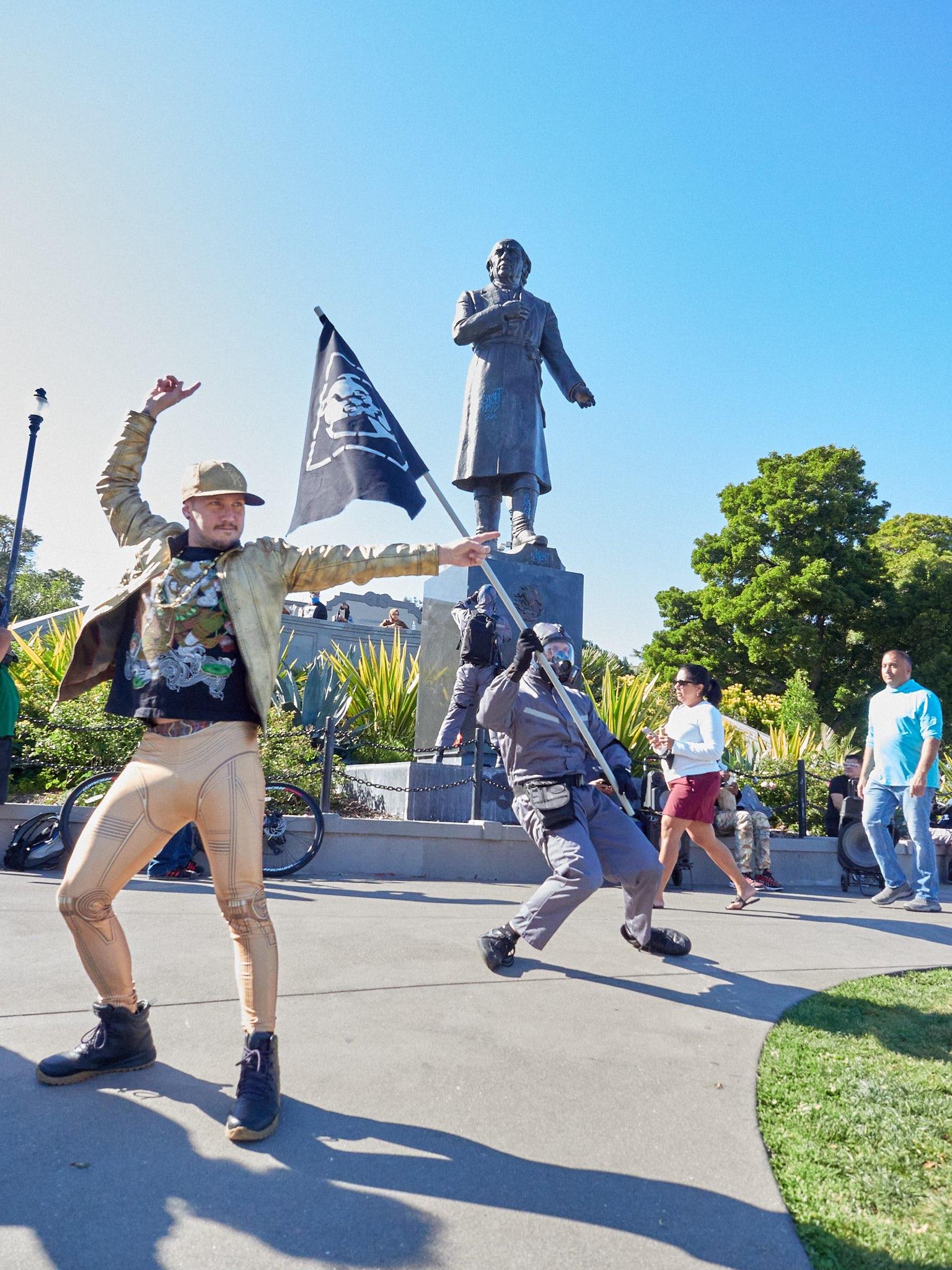 Two Glammonites in glittery outfits dance in front of a statue